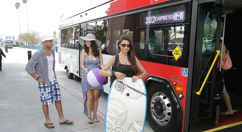 photo of people in front of an rta bus with beach gear