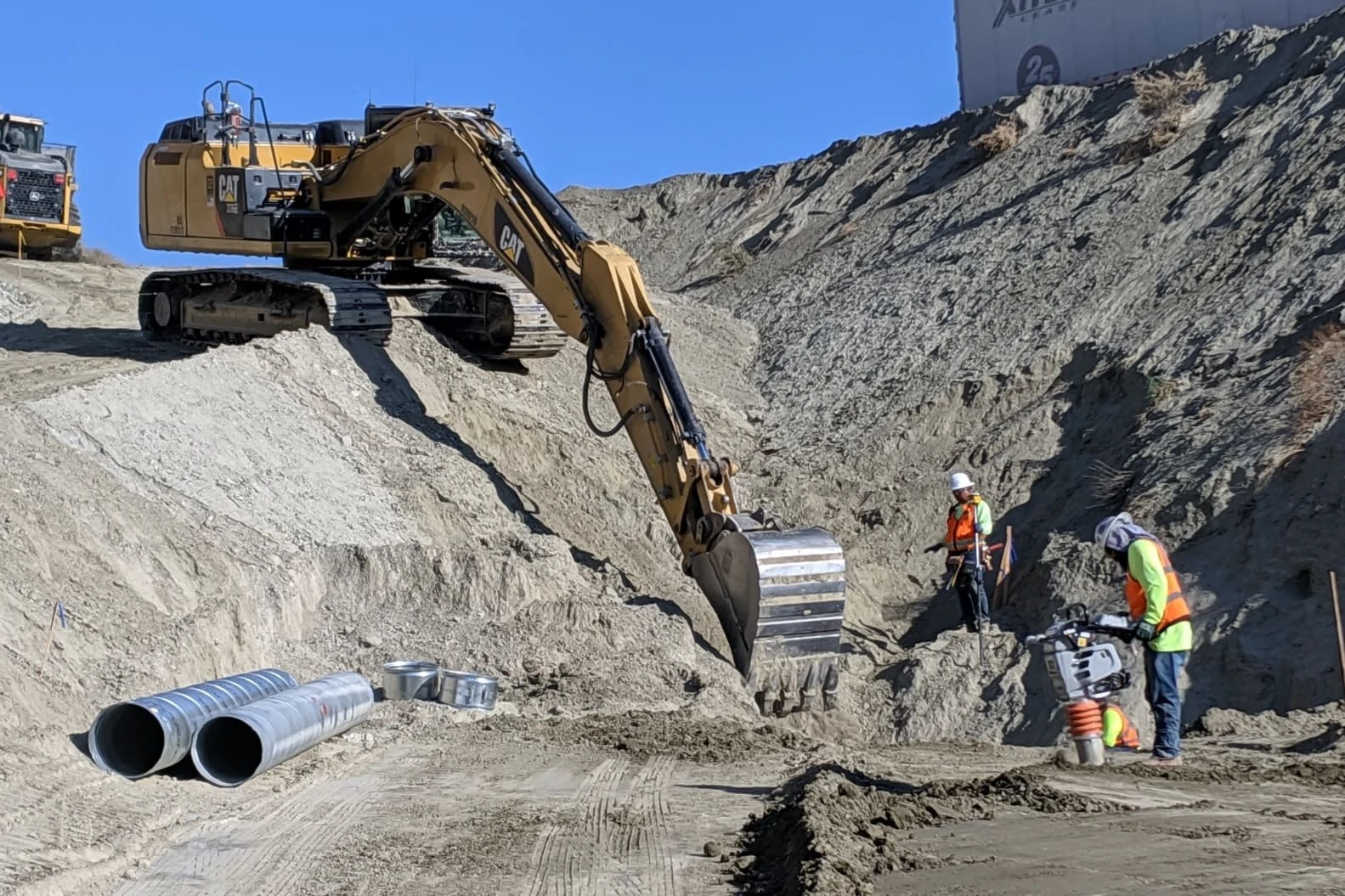 Excavator and crew digging drainage